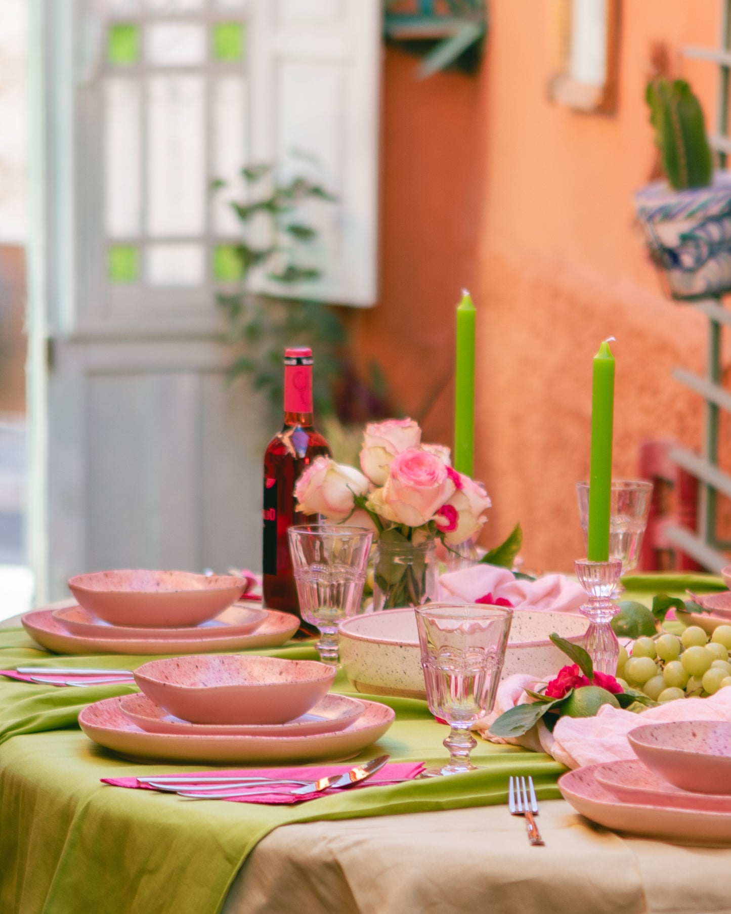 Mesa decorada con vajilla de cerámica de color rosado