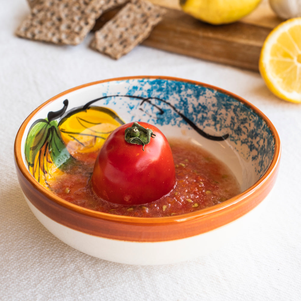 Foto de un plato rallador límon blanco, marrón y amarillo con tomates dentro